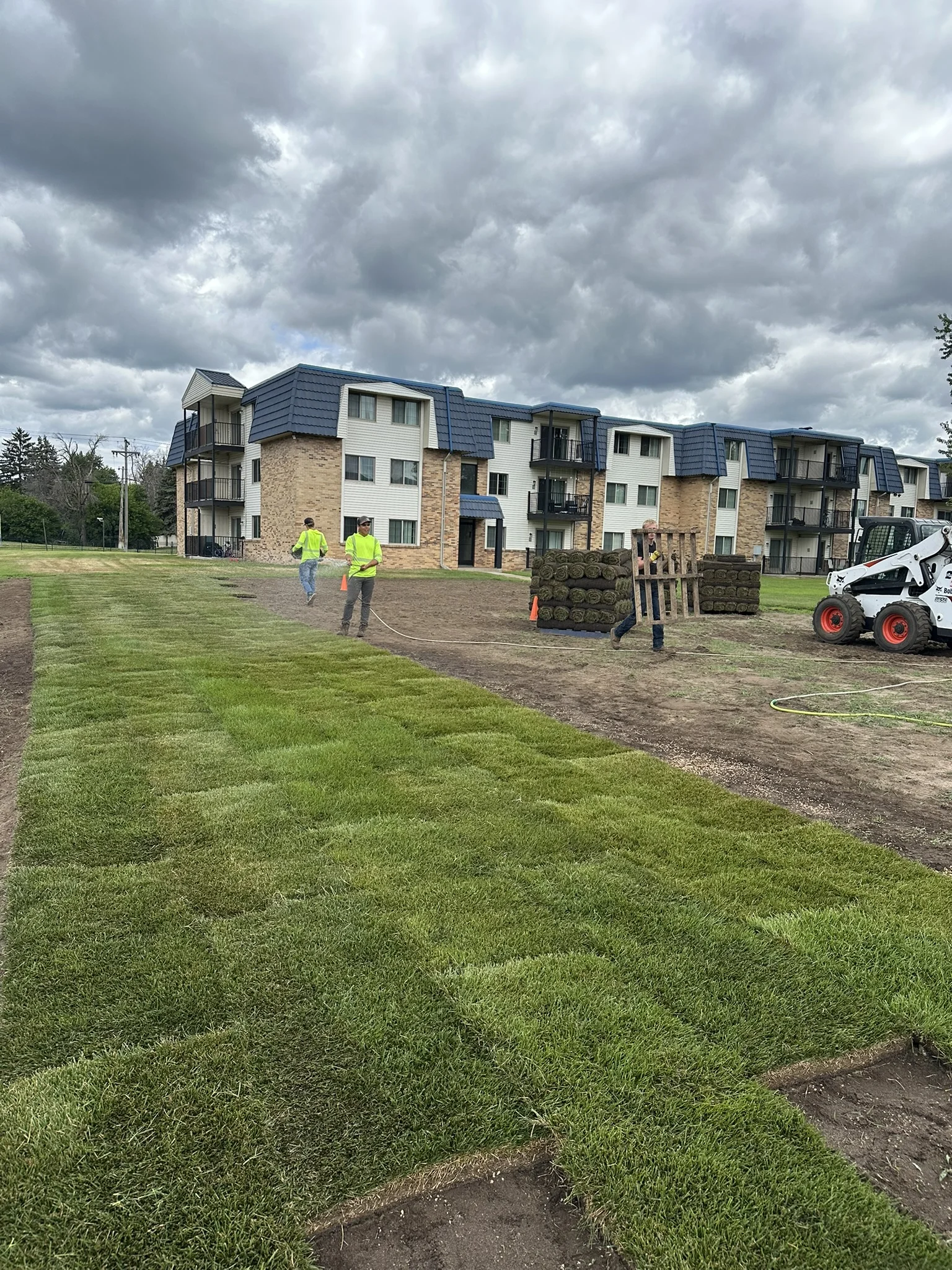 Clearline Outdoor crew watering in newly laid sod at a multifamily property in Brooklyn Center, Minnesota