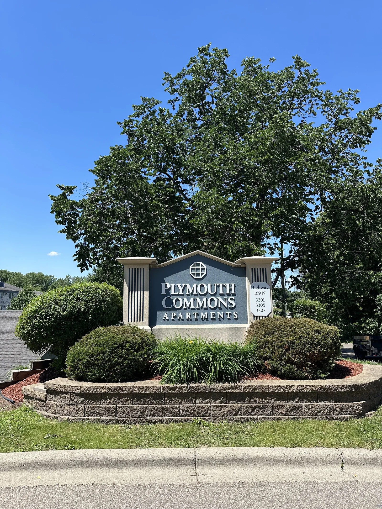 Plymouth Commons apartment monument sign with fresh mulch and new plantings in Plymouth, Minnesota