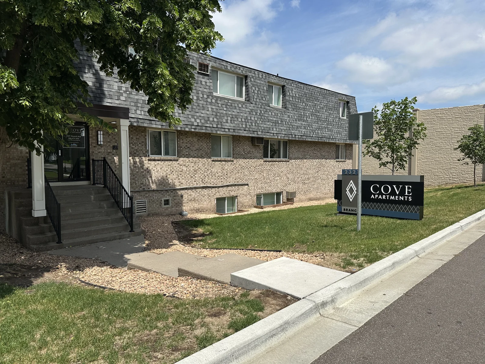 Cove Apartments monument sign corner before bed renovation, with minimal plantings