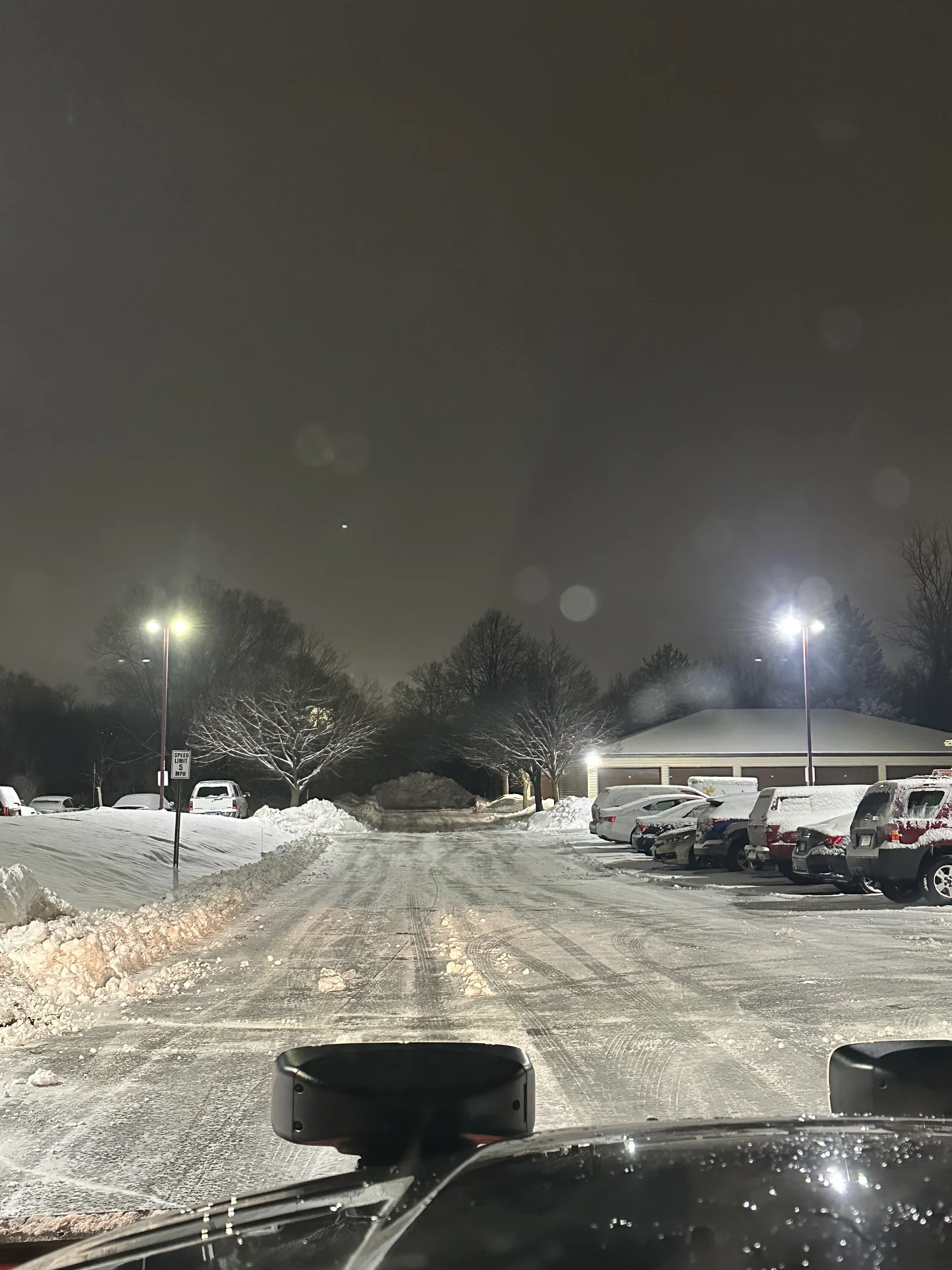Cleared drive lane down to pavement at Cloverleaf Apartments after an overnight snow removal visit in Blaine, Minnesota
