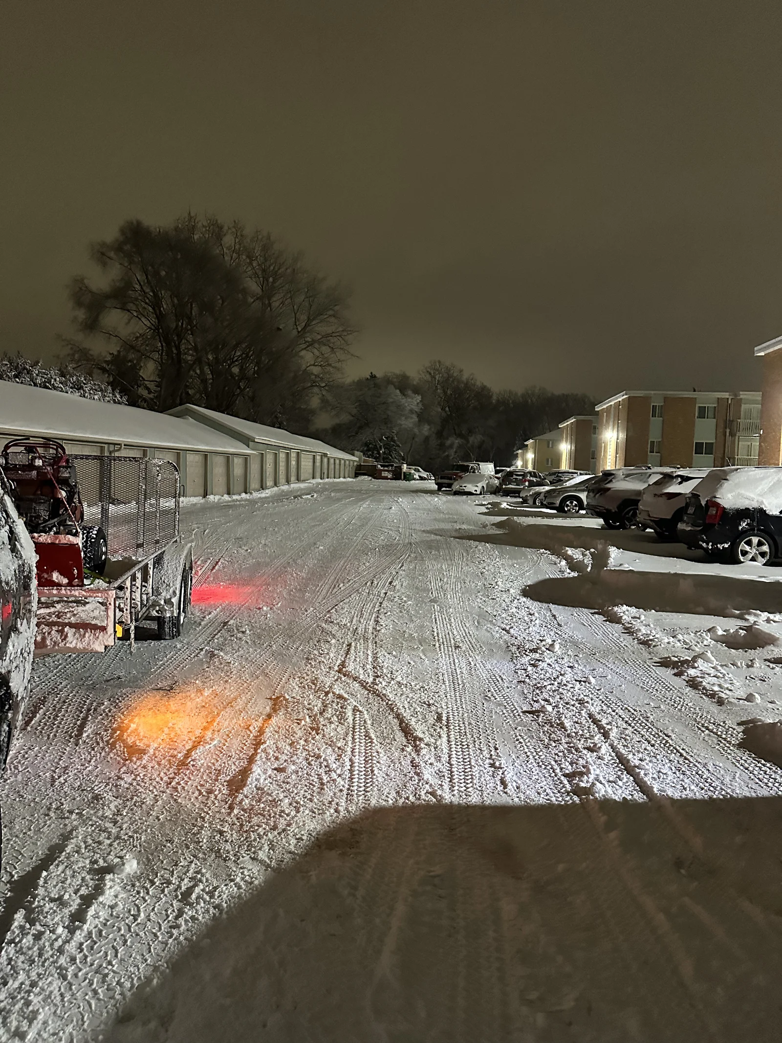 Clearline Outdoor equipment trailer past the garages at Granite Falls at Silver Lake Apartments in New Brighton, Minnesota during an overnight snow removal visit